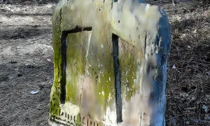 Smírčí kámen s vytesaným křížkem